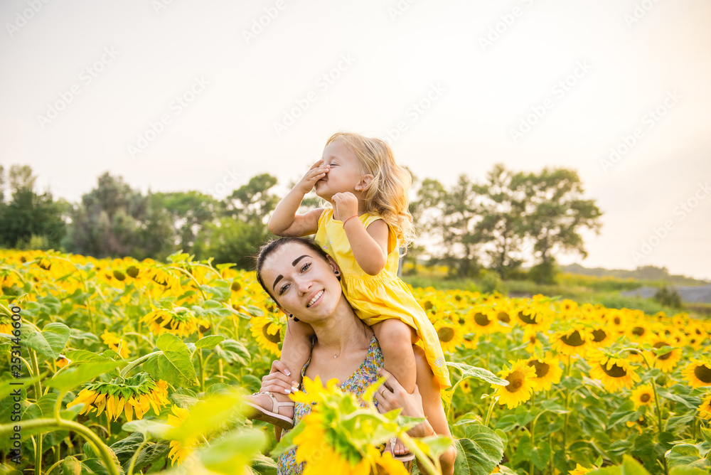 Mom and daughter in the field of sunflowers Mom and daughter in the field of sunflowers