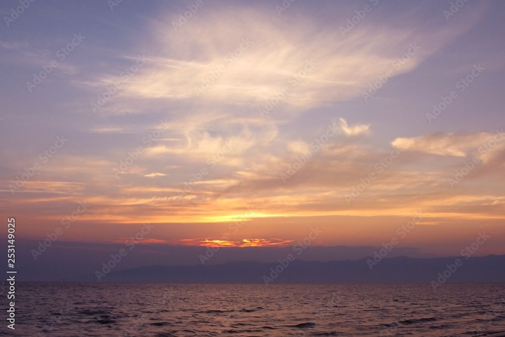 The sun sets over the sea, sunset over the pond, quiet evening, blue haze. Calm mood, meditation, peace.