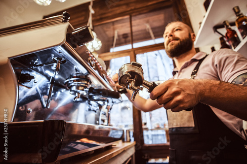 Low angle photo of a barista holding a portafilter  working in the coffee shop or restaurant