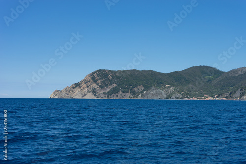 Italy,Cinque Terre,Riomaggiore, a large body of water with a mountain in the background © SkandaRamana