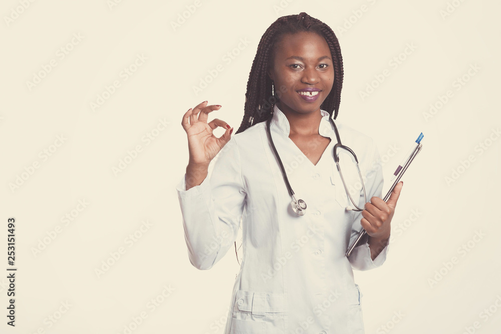 Female american african doctor, nurse woman wearing medical coat with stethoscope and hospital sheet chart with good results. Happy excited for success medical worker posing on light background