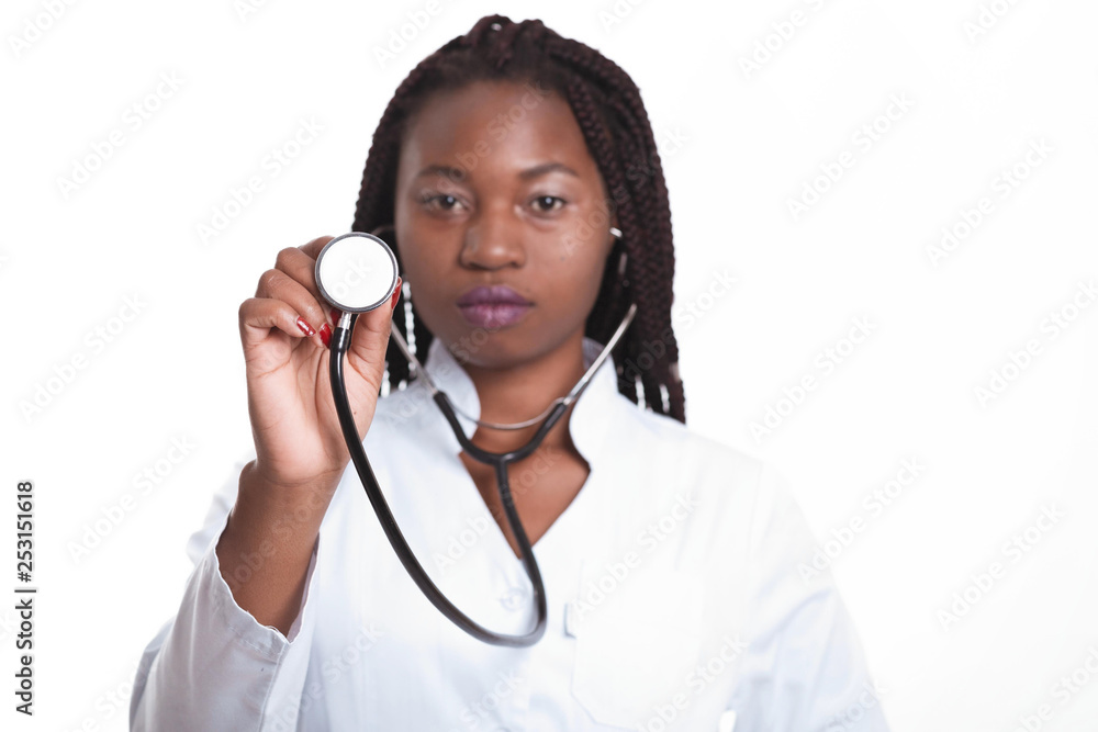 Female american african doctor, nurse woman wearing medical coat and using stethoscope. Serious excited for success medical worker posing on light background isolated