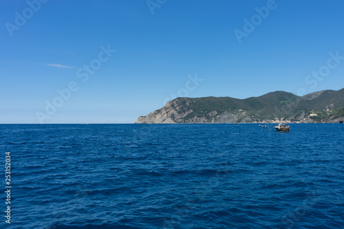 Italy,Cinque Terre,Riomaggiore, a large body of water with a mountain in the background © SkandaRamana