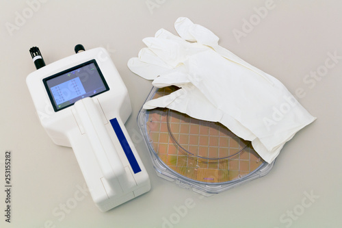 Konstfotografi Silicon Wafer in plastic holder box on a table with particle counter near