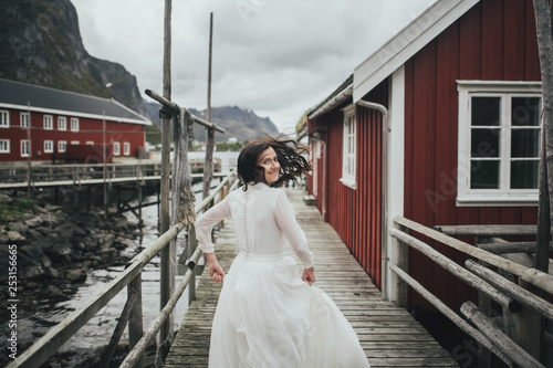 Wedding couple travelers on a hill in Norway, Kvalvika. Beautiful view of the beach, Lofoten, Norway. photo