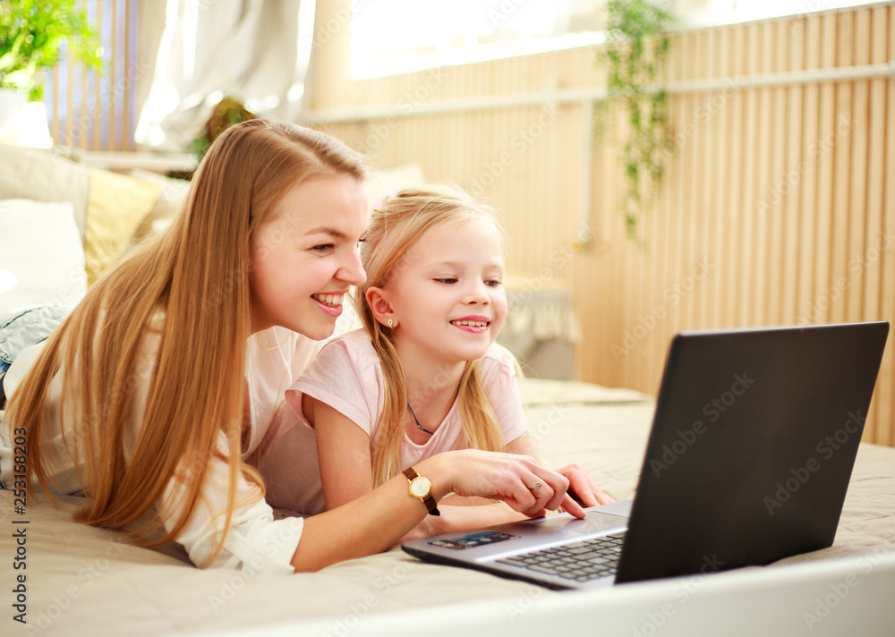 Happy family mother with daughter using computer laptop at home, modern lifestyle Happy family mother with daughter using computer laptop at home, modern lifestyle