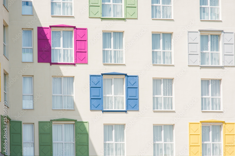 View to facade of building with windows with colored wooden shutters. View to facade of building with windows with colored wooden shutters.