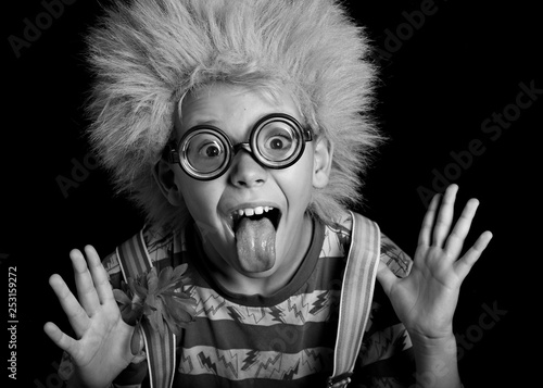 Wacky, zany , nutty child .clown ,boy in clown wig, suspenders  and crazy glasses