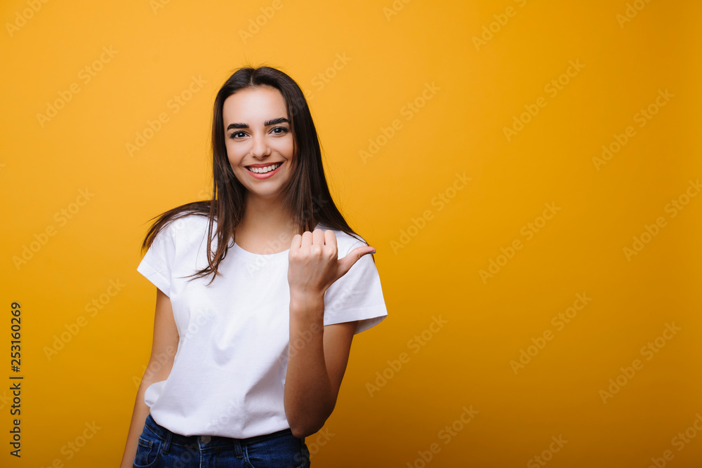 Φωτογραφία Cute young brunette smiling showing away advertising dressed in casual clothes i