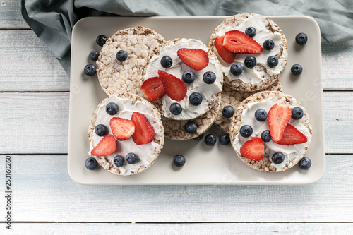 Принти на полотні Puffed whole grain crispbread with curd cheese, fresh strawberries and blueberries