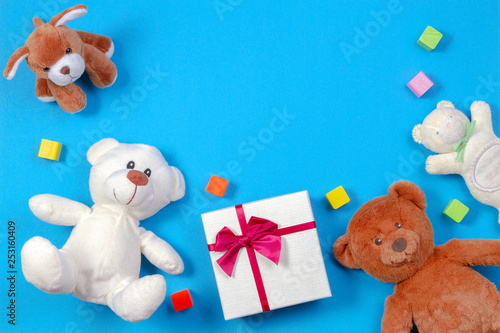 Kids baby toy background. Teddy bears, present gift box and other toys on blue background
