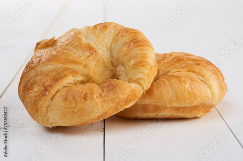 Fresh croissants isolated on wooden table