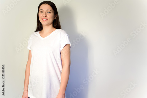Long-haired brunette in a white T-shirt. Stock for mockup. Copy space