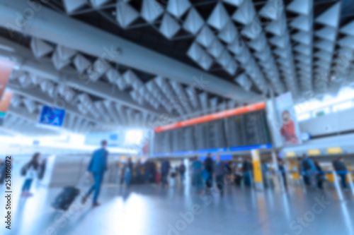 Inside of Airport with a lot of people. Airport interior with a flight information board. Blurred defocused image