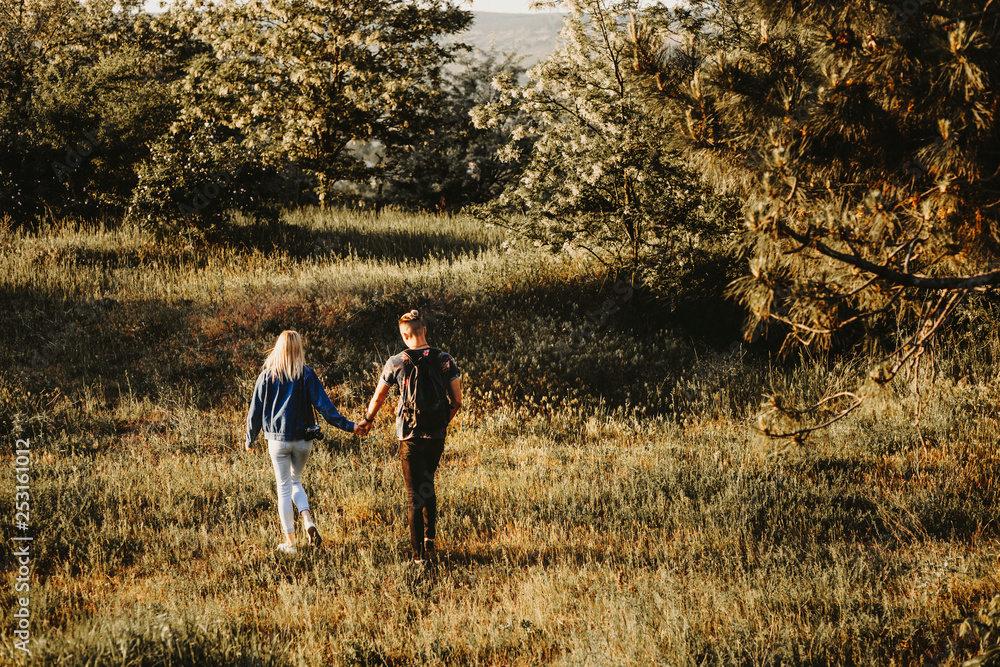 Full length portrait from back of lovely couple holding by hands and exploring new places while traveling.