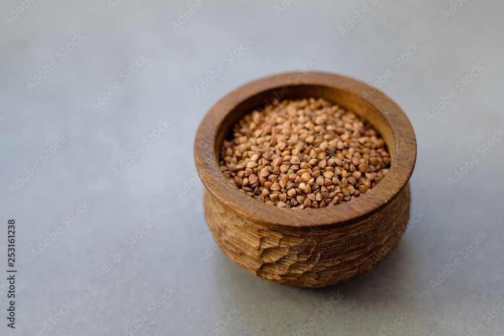 Buckwheat in a wooden bowl ongray stone background Buckwheat in a wooden bowl ongray stone background