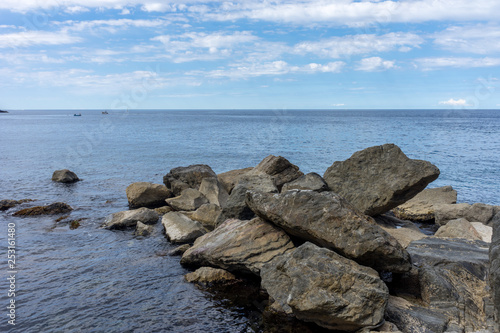 Italy,Cinque Terre,Riomaggiore, a rocky shore next to a body of water © SkandaRamana