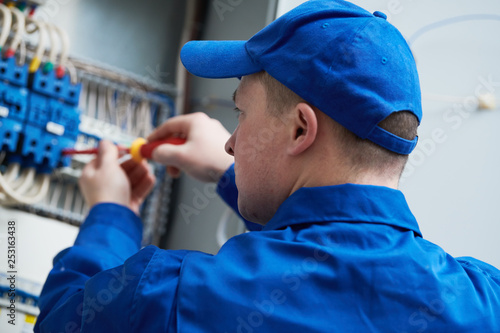 Electrician works with switchbox photo