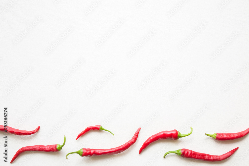 Beautiful red hot chili peppers on white table. Mockup for different ideas. Empty place for text. Flat lay. Beautiful red hot chili peppers on white table. Mockup for different ideas. Empty place for text. Flat lay.