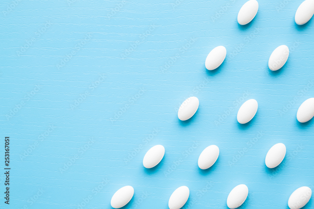 White pills on light pastel blue table. Drugs pattern. Medical, pharmacy and healthcare concept. Close up. Empty place for text, quote or sayings. White pills on light pastel blue table. Drugs pattern. Medical, pharmacy and healthcare concept. Close up. Empty place for text, quote or sayings.