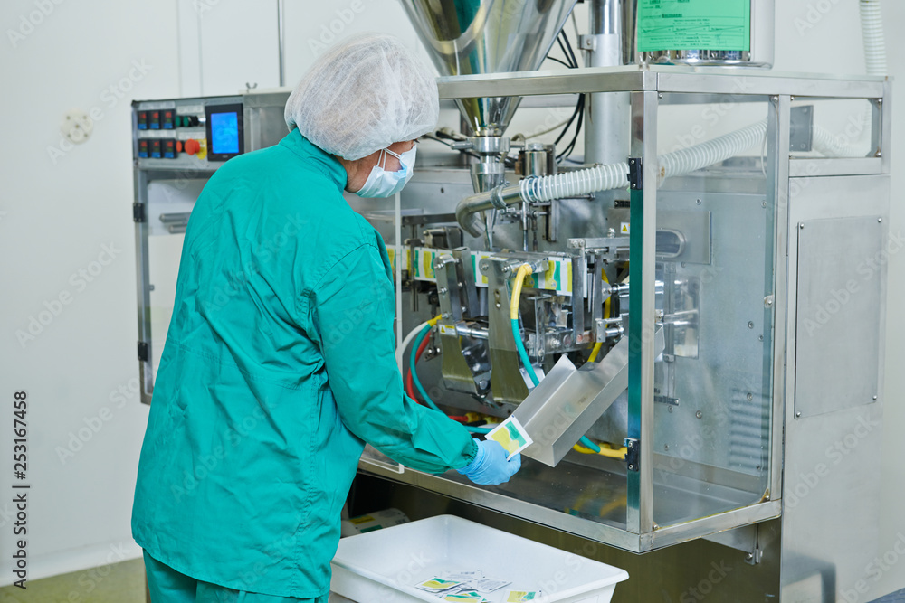 Naklejka premium Pharmaceutical industry. technician works with medicine packing machine