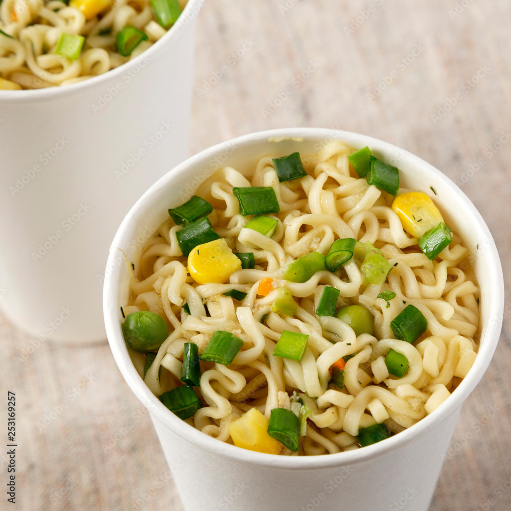 Fastfood: instant noodles with beef flavoring in paper cups, low angle view. Closeup. Fastfood: instant noodles with beef flavoring in paper cups, low angle view. Closeup.