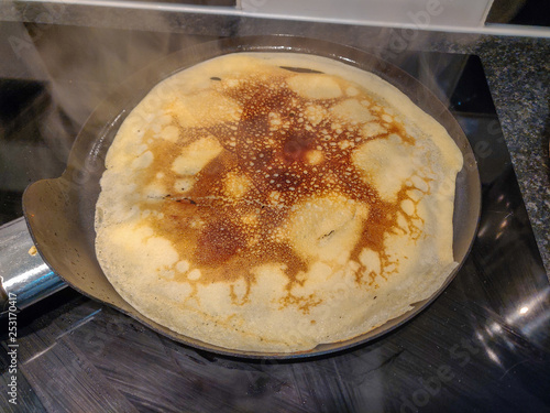 Crepe cooking in a frying pan