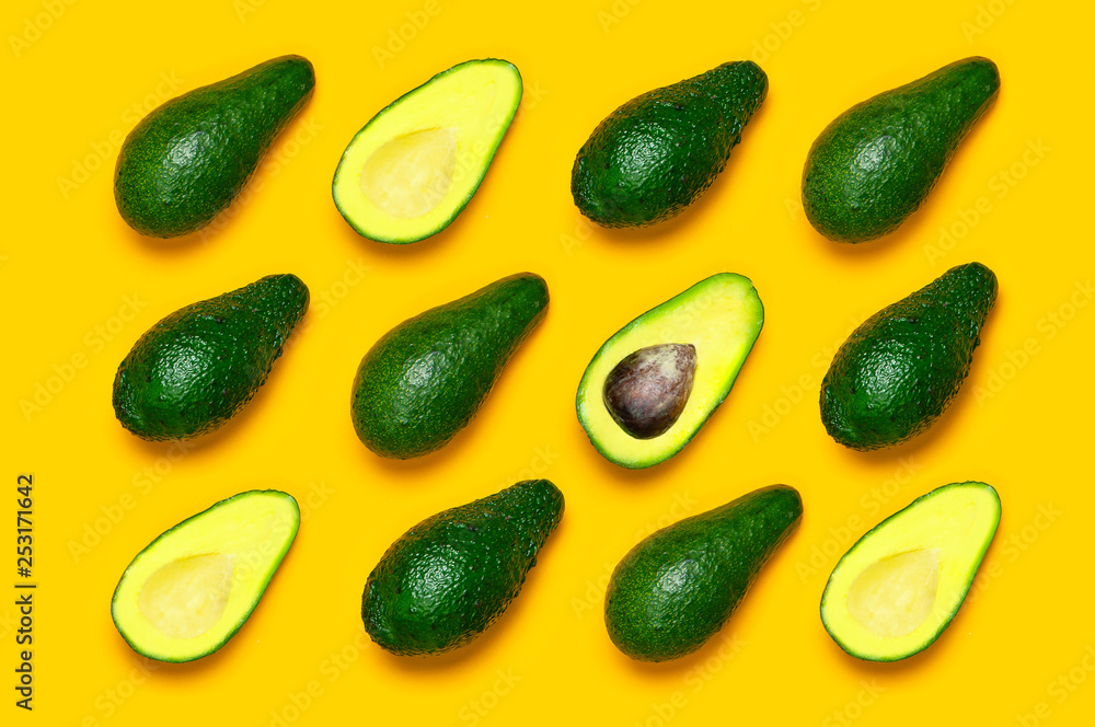 Ripe sliced avocado pattern on yellow background top view. Creative food composition Flat lay. Pop art design, tropical summer abstract background with avocado. Green avocadoes pattern. Ripe sliced avocado pattern on yellow background top view. Creative food composition Flat lay. Pop art design, tropical summer abstract background with avocado. Green avocadoes pattern.