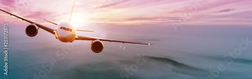 Obraz Samolot komercyjny lecący nad dramatyczny zachód słońca