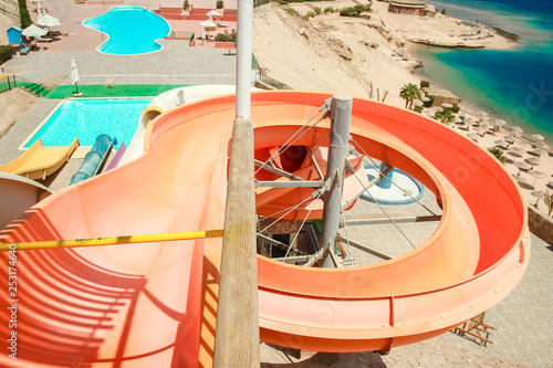 Stylishly interesting water slide in the pool near the sea on nature background