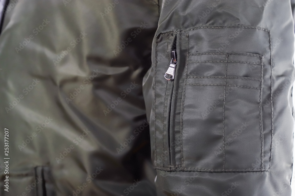 Naklejka premium Close up of olive green jacket sleeve zipper , winter fashion outfit. Jacket isolated on white background.