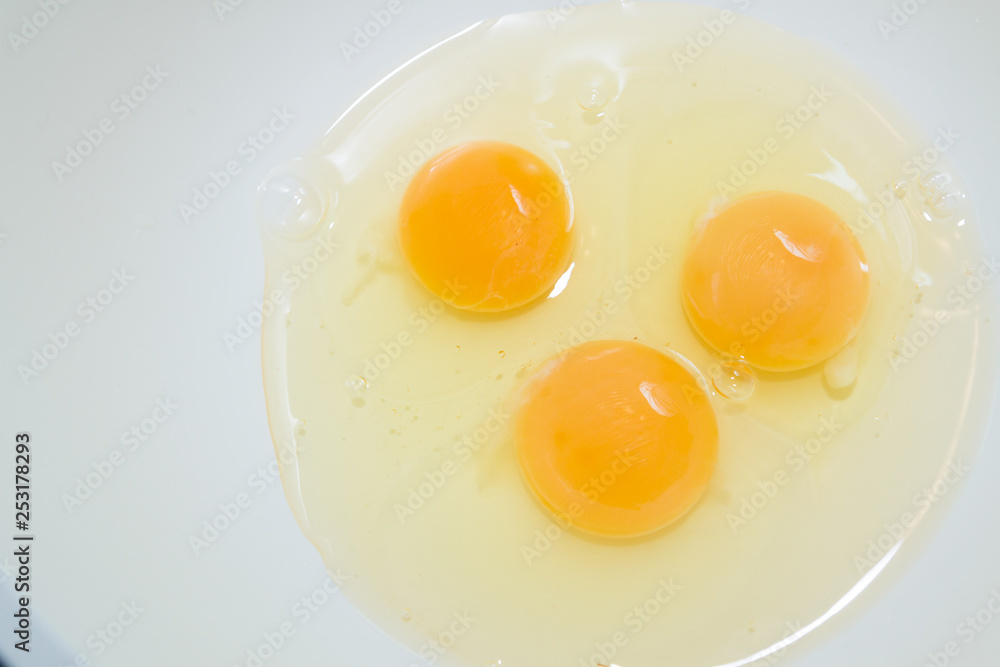 Three broken chicken eggs in a white mixing bowl Three broken chicken eggs in a white mixing bowl