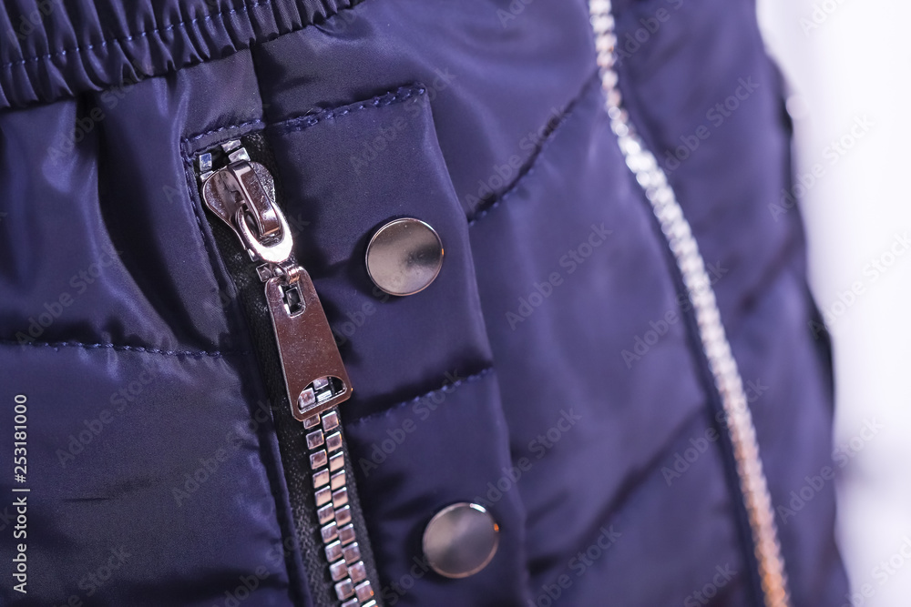 Close up of zipper on blue jacket pocket, winter fashion outfit. Jacket isolated on white background. Close up of zipper on blue jacket pocket, winter fashion outfit. Jacket isolated on white background.