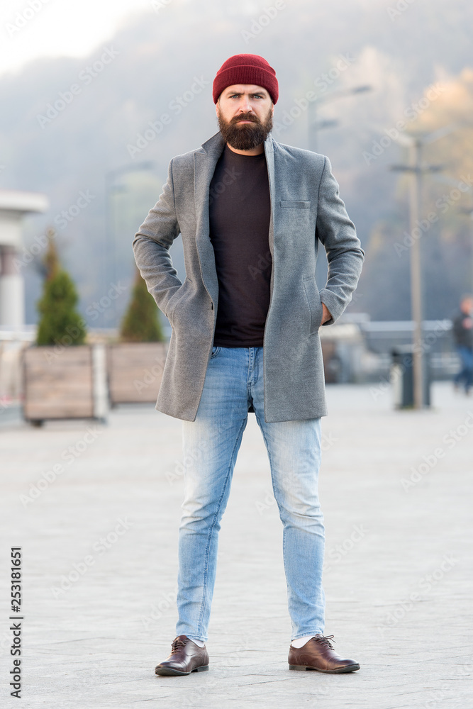 Hipster outfit and hat accessory. Stylish casual outfit spring season. Menswear and male fashion concept. Man bearded hipster stylish fashionable coat and hat. Comfortable outfit. Refreshing walk