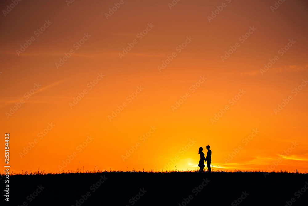 silhouette of a couple in love hugging together silhouette of a couple in love hugging together