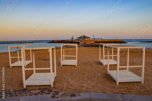 White beach chairs with red sand on the island of Fuerteventura- Caleta de Fuste