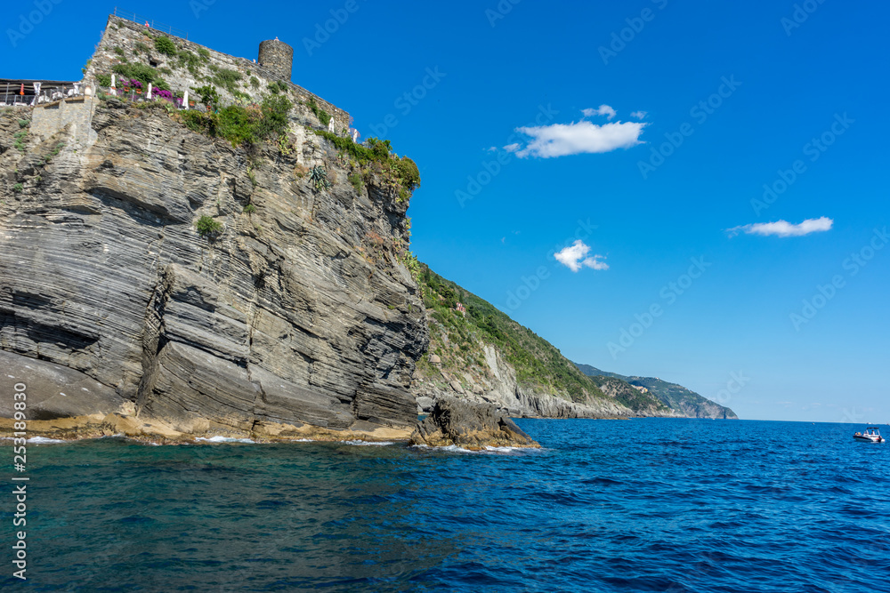 Italy, Cinque Terre, Vernazza, a large body of water with a mountain in the background Italy, Cinque Terre, Vernazza, a large body of water with a mountain in the background
