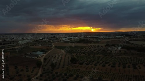 Aerial view of sunset over vineyards, pines and fields a stormy day