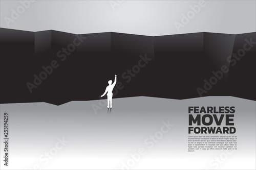 silhouette of businessman planning to cross abyss. concept of business challenge and courage man