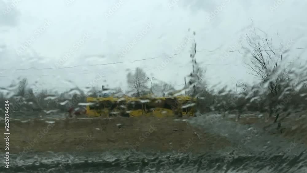 Rainy weather. Urban view of raindrops on the window glass. Spring summer weather with rain. Nature and road background. Time lapse. Rainy weather. Urban view of raindrops on the window glass. Spring summer weather with rain. Nature and road background. Time lapse.