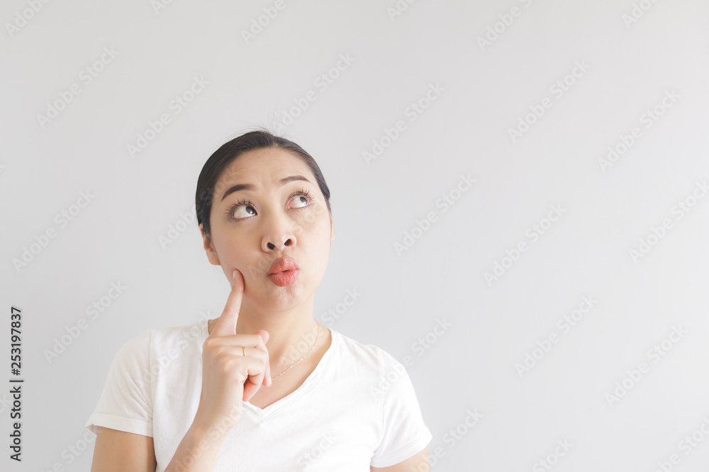 Happy woman in white t-shirt found an idea and looking at the empty background. Concept of happy idea advertising. Happy woman in white t-shirt found an idea and looking at the empty background. Concept of happy idea advertising.
