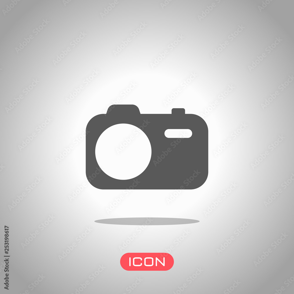 Simple photo camera. Technology icon. Icon under spotlight. Gray background Simple photo camera. Technology icon. Icon under spotlight. Gray background