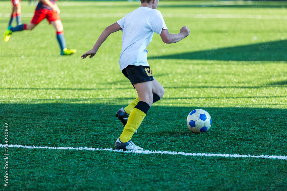 Football training soccer for kids. Boy runs kicks dribbles soccer balls. Young footballers dribble and kick football ball in game. Training, active lifestyle, sport, children activity concept Football training soccer for kids. Boy runs kicks dribbles soccer balls. Young footballers dribble and kick football ball in game. Training, active lifestyle, sport, children activity concept