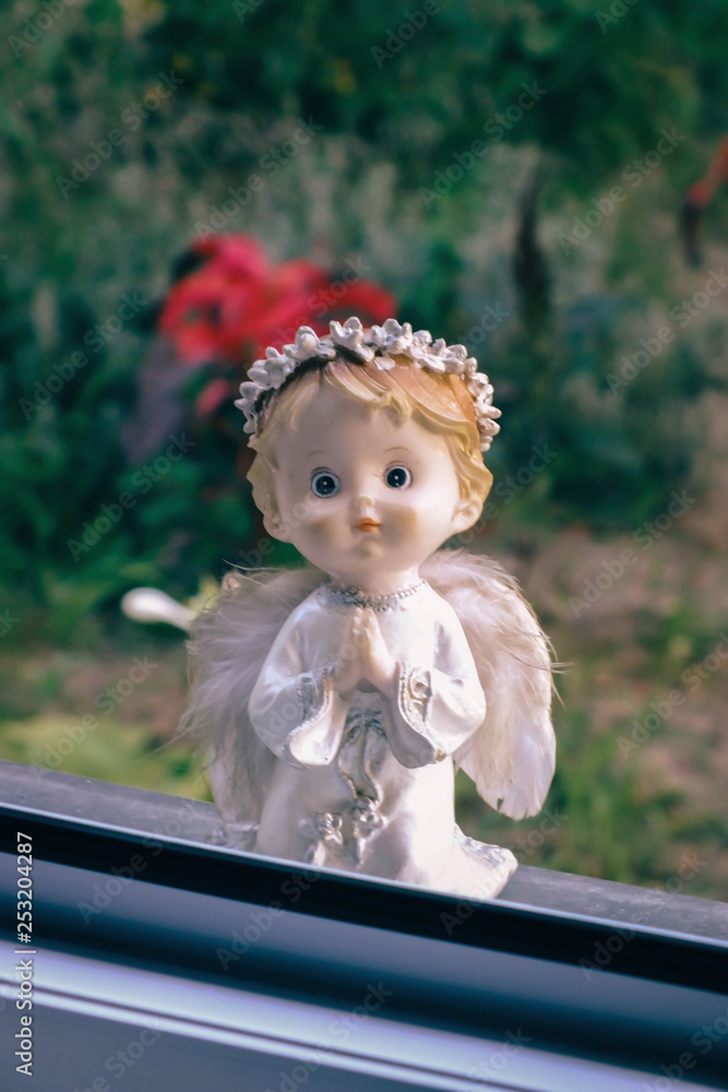 Fototapeta premium Angel looks out the window and prays. Religious symbol.