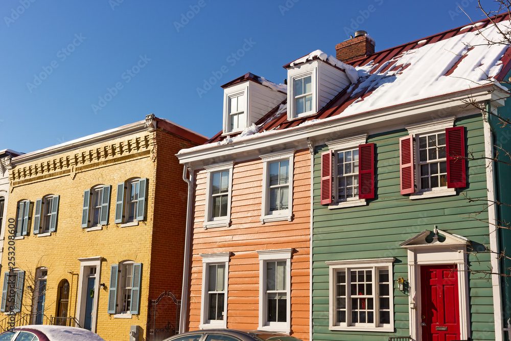 Fototapeta premium Historic houses of Georgetown suburb of Washington DC, USA. Colorful townhouses in a bright winter morning after snowstorm.