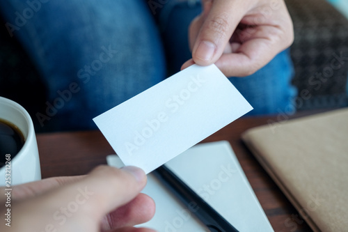 A woman holding and giving empty business card to someone