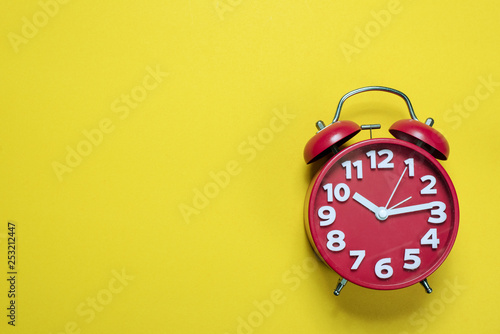 Red alarm clock images placed on a yellow background, time concept with copy space photo