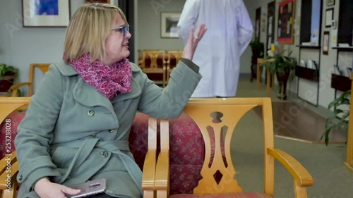 Female patient watching a doctor walk by and expressing her frustration