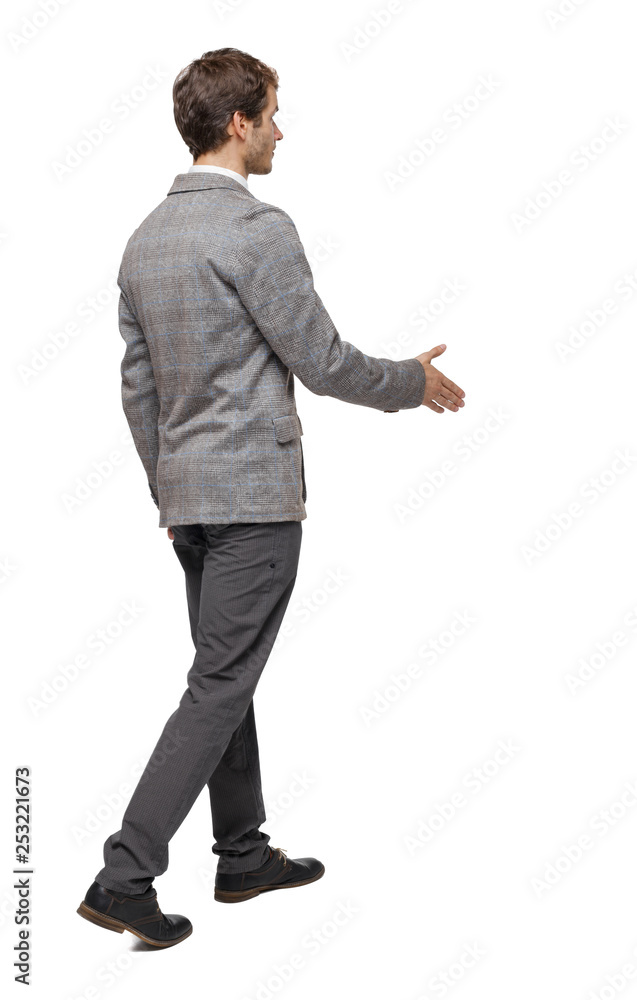 Back view of a walking businessman who stretches his hand for a handshake. Back view of a walking businessman who stretches his hand for a handshake.