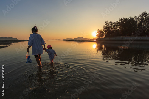 Mather and son on the beach at sunset